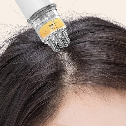 White scalp serum applicator with multiple roller balls positioned along a hair part