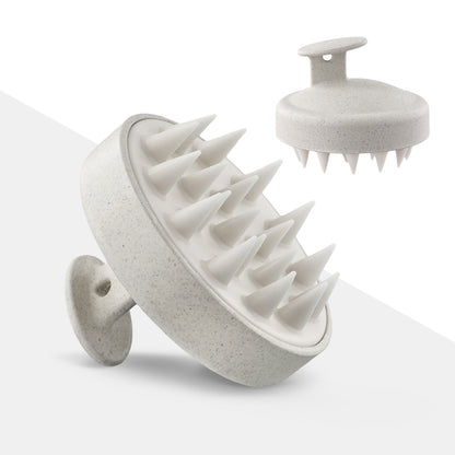 White round palm-held scalp shampoo brush showing silicone massage teeth and a small top grip